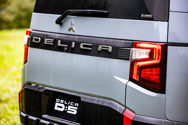 「DELICA」のロゴがガーニッシュに入るシンプルなデザインに改められた「デリカD：5」のリアゲート。リアガーニッシュのデザイン変更により、従来型でガーニッシュに内蔵されていたバックランプは、リフレクターの下部に移動している。