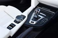 センターコンソールにはサスペンションおよびステアリングの調節スイッチや、インフォテインメントシステムの操作スイッチ、ルーフの開閉スイッチなどが並ぶ。