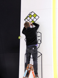 プレスデイ初日昼、オペルのブースで黙々とテープドローイングをする人を発見。