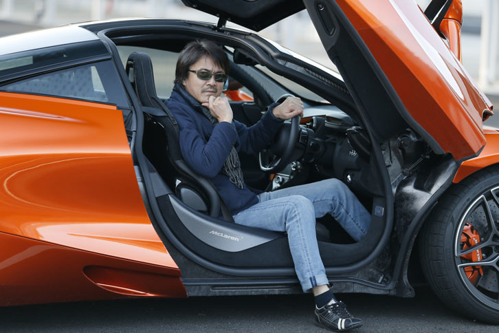 運転席でポーズをキメる筆者。最低地上高は通常107mmで、オプションの「車両リフトシステム」を使用するとフロントのみ134mmにまで上げられる。