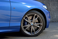 写真の18インチアロイホイールは、「M235i」の標準アイテム。タイヤは、エントリーモデル「220i」に備わるランフラットタイプとは異なる、「ブリヂストン・ポテンザS001」が組み合わされる。