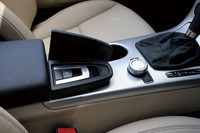 ルーフの開閉スイッチは、肘かけの下にある。写真でその右側（車体前方）に見られる円形のノブは「COMANDシステム」の操作スイッチ。タッチパネルと違い、正しい運転姿勢を崩すことなく手の届く範囲でカーナビゲーションなどの操作ができるというのがウリ。