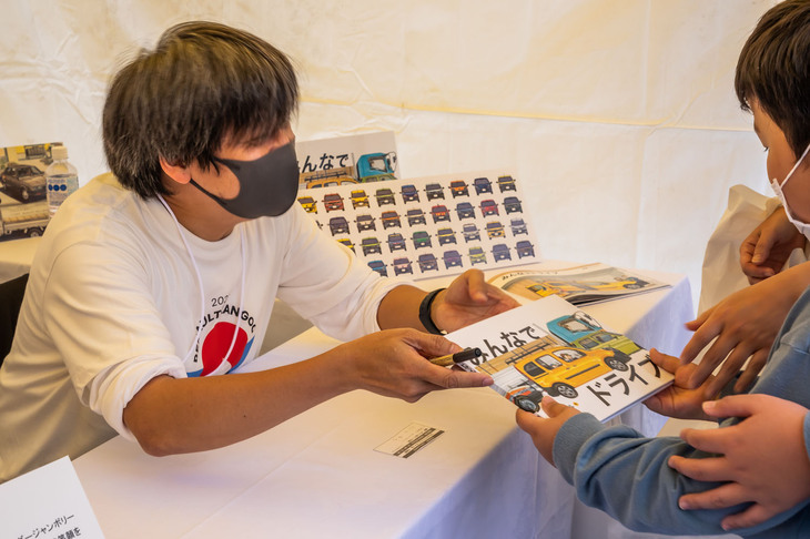 『みんなでドライブ』の作者・遠藤イヅルさんから、サインをもらった未来の「カングー」オーナー？　うれしそうな笑顔が印象的。