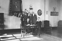 リンカーンは1922年にフォードの傘下となる。写真はその調印の様子で、テーブルの後ろにヘンリー・リーランド（右）とヘンリー・フォード（左）が立っている。