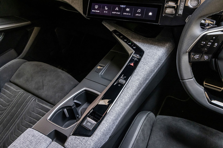 運転席側が高く、助手席側が低い特徴的なセンターコンソールデザイン。ピアノブラックのコンソールパネルには、ドライブモードセレクターやハザードスイッチ、オーディオのオン／オフ、ボリュームスイッチ、サイドブレーキスイッチなどが直線的に並ぶ。