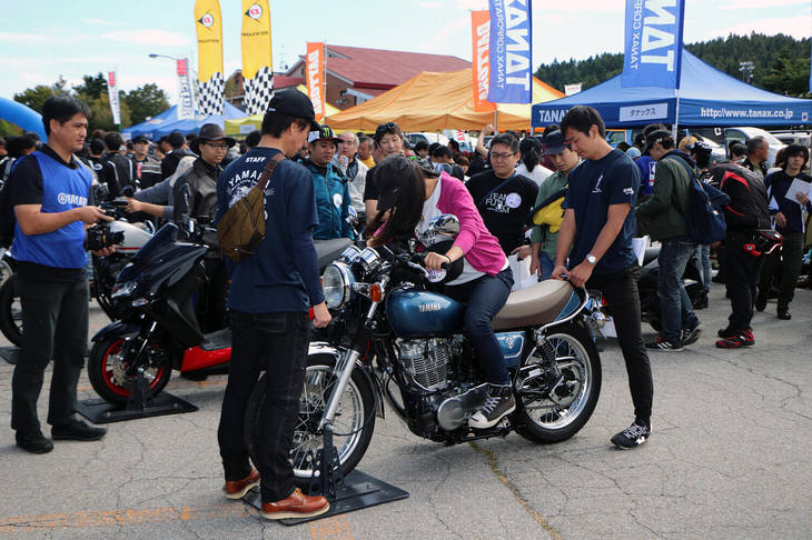 40年を超える歴史を持つヤマハの名車「SR400」も展示。改良が続けられ、今も現役モデルだ。エンジン始動がセルモーターではなく、キックのみというのもマニアック。乗用車に例えるなら、「ケータハム・スーパーセブン」のような存在だろうか。写真は、女性がキックスタートに挑戦しているところ。