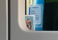 交通安全祈願もばっちり。運転席横には聖人のお守りステッカーが。さらにルームミラーには十字架がかけられていた。