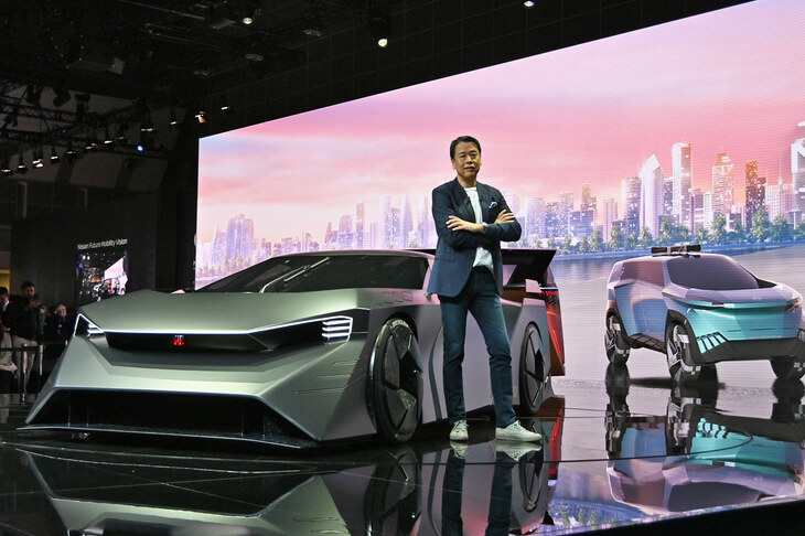 「ハイパーフォース」と日産の内田 誠社長。ステージのディスプレイには、デジタルモデルの「ハイパーアドベンチャー」が映っている。