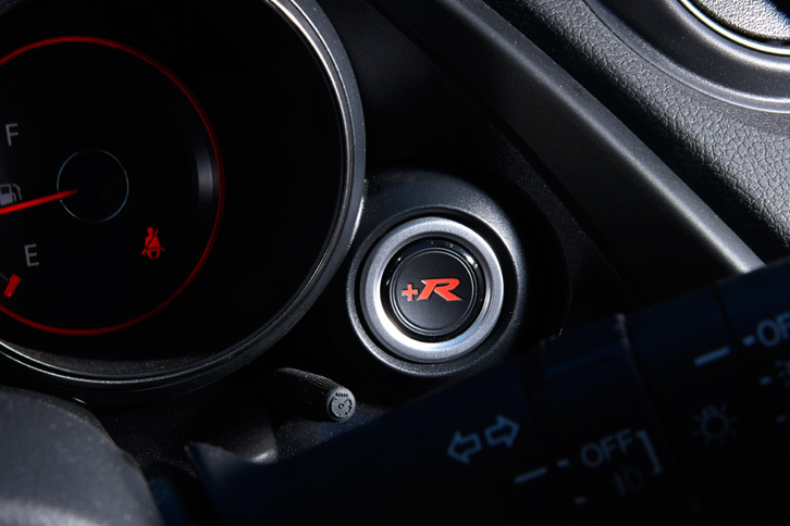 メーターの横に装備された「＋R」ボタン。エンジンや電子制御ダンパー、電動パワーステアリングなどの特性を、よりサーキット走行寄りに切り替えることができる。