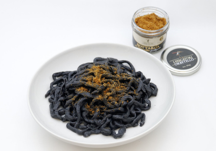 ヴァスコさんの店で販売されているボラのからすみを、シエナ風の太麺ピチ・イカスミ風味にかけて食す。