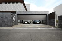 フラットデザインのスチール製ガレージシャッター「ポルティエ」の施工例。建物にマッチしたチャコールネズコのシャッターの内側にはミニとマクラーレンGTが収められている。
