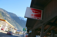 軒先にはダイハツの看板が。部分的な退色が、日照時間が限られた山あいの村であることを物語っている。