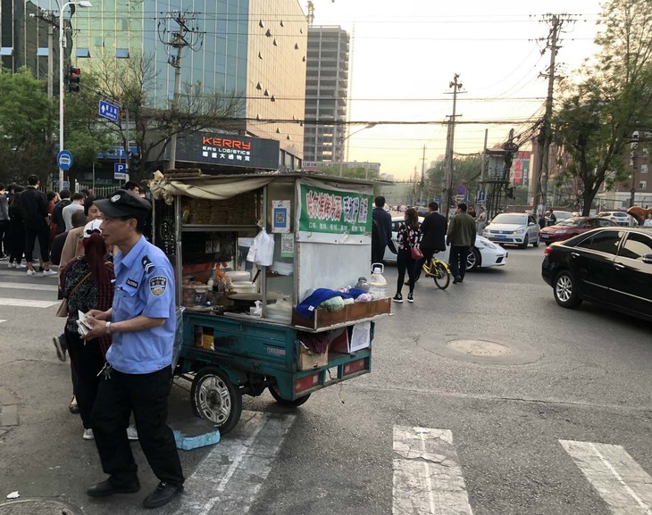 冷麺の屋台、そのかなたにポルシェ。自転車に乗ると、エキサイティングな北京を別の視点で楽しむことができる。
