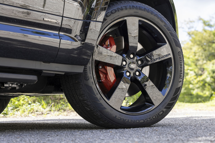 グロスブラックの「スタイル5098」と呼ばれるオプションの5スポークデザインホイールから顔をのぞかせるオレンジのブレーキキャリパーは、「X」グレードの専用アイテム。タイヤは275/45R22サイズで、試乗車には「コンチネンタル・クロスコンタクトRX」が装着されていた。