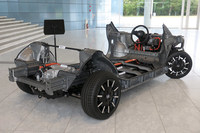 「ホンダe」のランニングシャシー。リアに置かれたパワートレインが、非常にコンパクトで、低い位置にまとめられていることが分かる。モーターそのものの構造の簡単さに加え、かさばるトランスミッションが不要なことも、EVパワートレインのコンパクトさに寄与する。