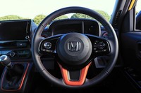 オレンジの差し色が強烈なステアリングホイールは「RS」専用デザイン。右スポークには全車標準の安全運転支援システム「ホンダセンシング」のスイッチ類がレイアウトされる。