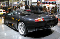 
	ブースのもう一方を飾るのが、ガヤルドの“兄貴”「ムルシエラゴ」。発売当初に設定のなかった「e-gear」装着車の設定はニュースだ。6.2リッターV12エンジンは可変バルブタイミング、可変インテークシステムなど、電子制御技術が取り入れられ、580psと66.3kgmを発生。足まわりは4輪ともダブルウィッシュボーン／コイルの可変ダンパー付となり、フルタイムで4輪を駆動する。
	なおブリーフィング中には、各国のGTレース、ルマンなどにも出られるレース仕様「ムルシエラゴR-GT」についても言及された。
	 