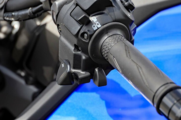 左スイッチボックスに備わるシーソー式のシフトレバー。人さし指で「＋」レバーを押してシフトアップ、親指で「－」レバーを押してシフトダウンできるほか、「＋」レバーを人さし指で前にはじく（前側に押す）ことでもシフトダウンができる。