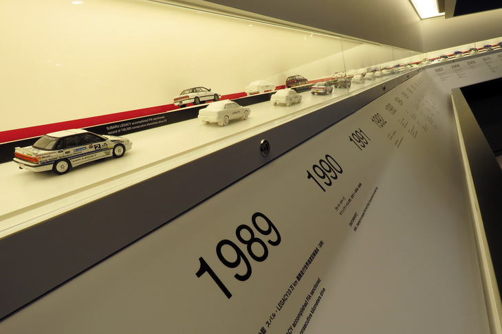 トロフィーの下には、STIが手がけた歴代のラリーカーやレーシングカー、コンプリートカーのミニカーを展示。