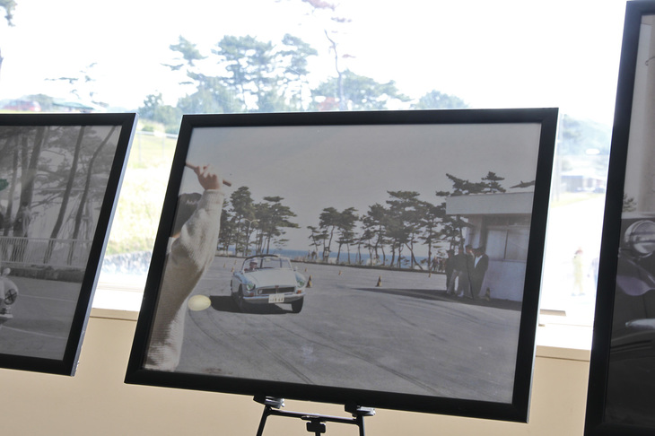 写真パネルの中から、1960年代に大磯ロングビーチで開かれたジムカーナにおける生沢氏の「MGB」。防風林の松は今も昔も変わらないことがわかる。