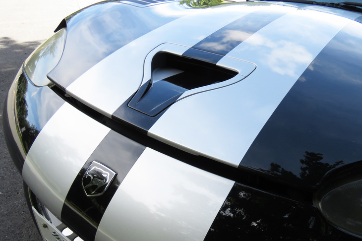 わが「バイパー」のカウルは、まずはフロントグリル内のレバーを引いて1段目のロックを解除、次に、この隙間からステーを引いてフックを外し、後方からガバチョと開ける。レスキューのお兄さん、残念でしたな。