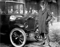 1921年型「T型フォード」とヘンリー・フォード。フォードは1913年にハイランドパーク工場にベルトコンベヤーを使った生産ラインを完成させ、前例のない大量生産を実現した。