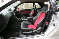 赤と黒で統一されたインテリア。3点式シートベルトや、リアシートは残される。