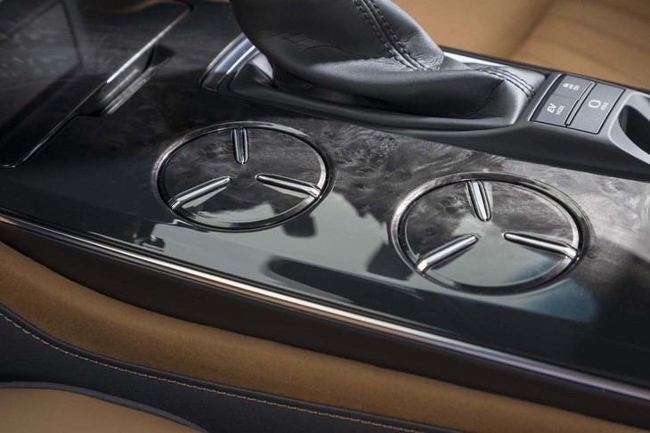 滑らかな昇降感が印象的な、可動式カップホルダー。周囲のパネルとともに、欅（けやき）調の黒木目パネルが上質な室内を演出する。