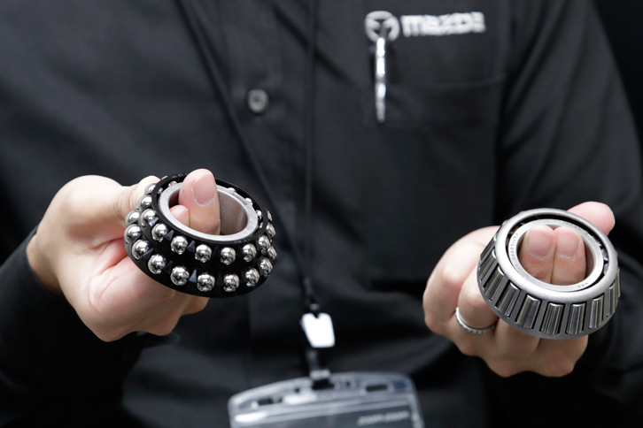 新型「CX-5」では、トランスファーとリアデファレンシャルのすべての軸受けを、テーパーローラーベアリング（写真右）からボールベアリング（同左）に変更。抵抗によるエネルギー損失を抑制している。