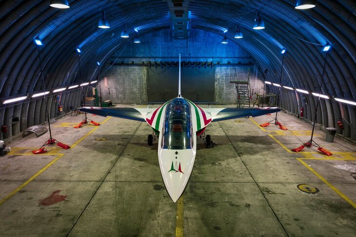 格納庫で。「レオナルドM346」は練習機兼軽攻撃機で、訓練生用・教官用にタンデムシートを持つ。製造元であるレオナルドの資料によると翼幅（ウイングスパン）は9.72m、全長は11.49mとされている。