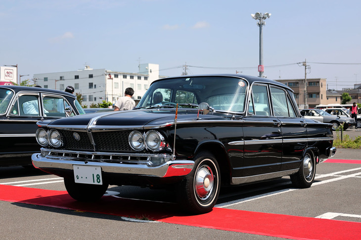 誕生60周年を迎えた2代目「プリンス・グロリア」のなかに、超希少車である1965年「グランド グロリア」（S44P-1）がいた。2.5リッター直6エンジンを積んだ、当時は禁止税的に自動車税が高額だった3ナンバーの最高級グレードである。エクステリアは専用のフロントグリルを持つマスク、専用ホイールキャップ、クロームメッキされたサイドシルのプレート、エンブレム類などで差別化されている。