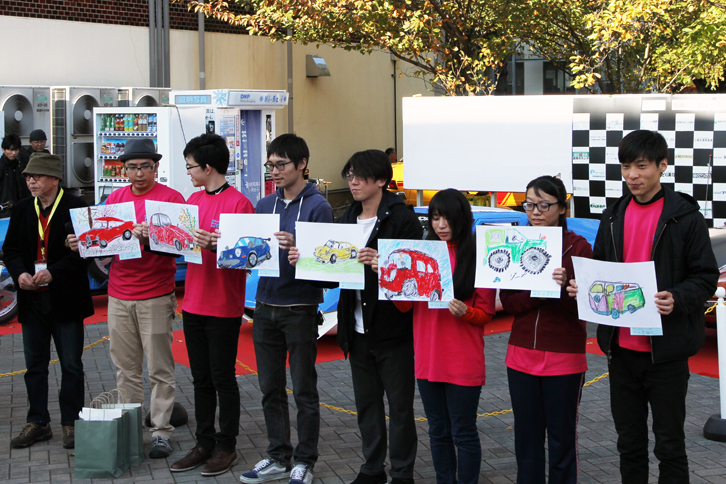 「子どもお絵描き大会」の優秀作品が発表され、受賞者は表彰を受けた。みな特徴をよくとらえている。おわかりとは思うが、作品を抱えているのは作者ではありません。