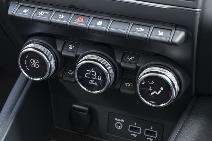 鍵盤型スイッチの下に、エアコンの操作ダイヤルを組み込んだセンターコンソール。その下部にUSBポートやスマートフォン用のワイヤレスチャージャーを配置している。