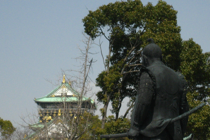 大阪城を見つめる豊臣秀吉像。贅沢は身を滅ぼす。