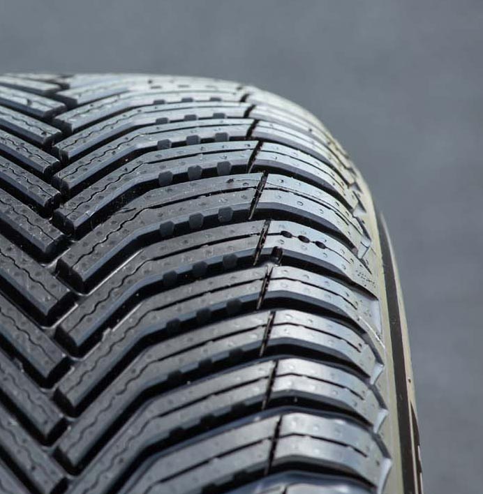 「クロスクライメート2」は性能の持続性もセリングポイントのひとつ。摩耗が進むに従ってブロック側面に新たな凹凸と溝が現れ、排水・排雪性をキープする仕組みになっている。写真でショルダー部に見られる3つのドット（点）は、摩耗度を示す独自のセンサーである「トレッドウェアサイン」。道路運送車両法に基づくスリップサインは別途用意される。