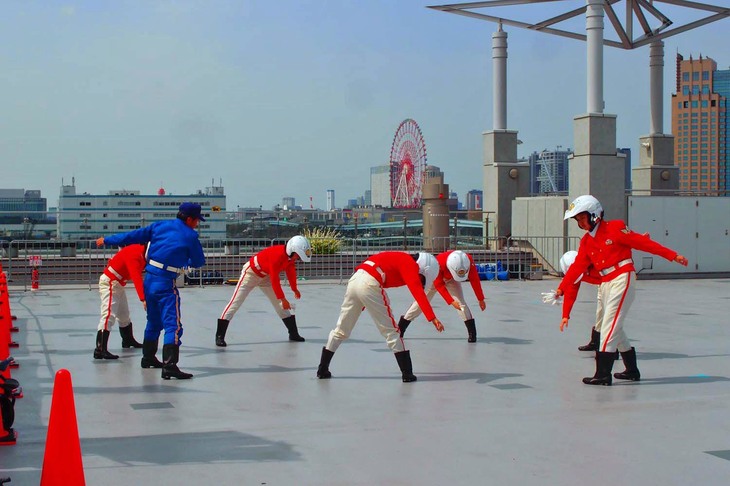 屋外のスペースを使って、女性白バイ隊員によるデモンストレーションも実施された。写真は、その準備運動の様子。