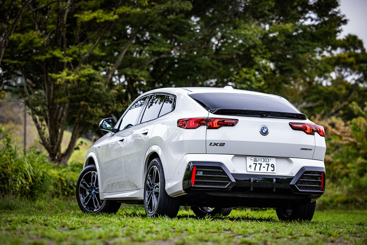 ルーフからボディー後端へとなだらかなラインを描くクーペライクなシルエットと、矢印がモチーフと紹介されるリアコンビランプデザインが目を引く「iX2」のリアビュー。