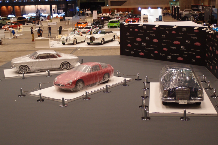 会場入り口付近の「主催者コーナー」では、カバーをかけられた3台のクラシックカーが開会のときを待つ。写真左から「シボレー・コーヴェア モンザ」（1963年）と「アルファ・ロメオ・ジュリアTZ」（1965年）、「メルセデス・ベンツ220SEb」（1961年）。