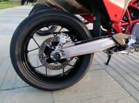 「SM700」のホイールは前後とも17インチのキャストホイールとなる。写真はリア側で、折れそうなほど細身のスポークが印象的だ。スイングアーム（単体で重量3.9kg）は、溶接が施されない鋳造品となっている。