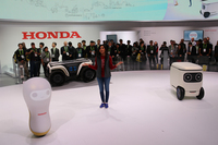 ホンダのロボット紹介。写真左は“人とコミュニケーションする”「3E-A18」。中央奥はアタッチメント交換で消火活動などにも使える「3E-D18」、そして右は“人との関わりを通して、より人のためになるよう自らを成長させていく”という「3E-C18」。