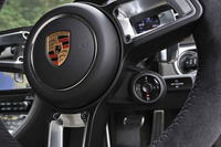 盾形のエンブレムが輝くステアリングホイール。そのセンター右下には、ダイヤル式の「プログラムスイッチ」を装備。好みの走行モードが選択できる。