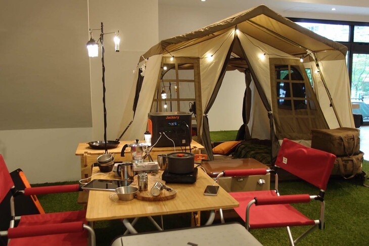 アウトドアでのキャンプシーンを再現したブースにて。照明にホットプレート、タブレットからポータブル冷蔵庫まで、電源を必要とするさまざまな電気製品の真ん中に「1000 Pro」がいる。昭和な言い方をすれば“大黒柱”。カッコつければ“ハブ”な大容量ポータブル電源。そのありがたみと安心感は絶大なのだ。2022年のいま、モバイルバッテリーの要不要を言うのはもはやナンセンス？（ナンセンスは昭和の死語）