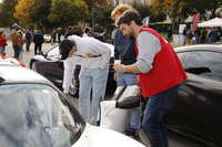 来場者を相手に、愛車「ロータス・エキシージ」のコックピット着座を勧めるオーレリアンさん（写真右）。