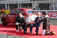 「海外レース参戦50周年パレード」で、「ダットサン富士号」に乗って登場した難波靖治氏（中右）とブルース・ウィルキンソン氏（中左）。クラス優勝の勝因は「クルマが頑丈で、壊れなかったことにつきる」と語っていた。