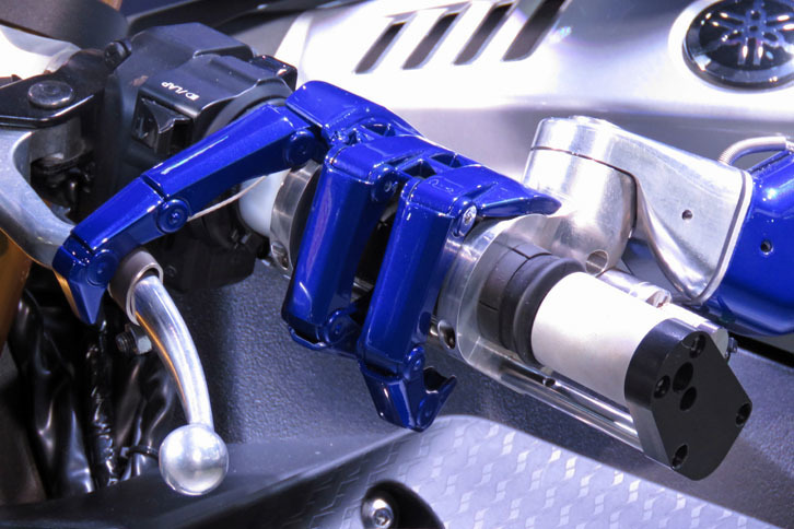 「MOTOBOT」は、アクセルやクラッチなどを人間と同じように手や指（のようなパーツ）で直接操作する。