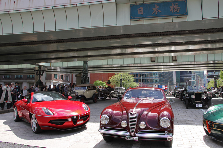 日本橋橋上にて。先頭中央に「コンコルソ デレガンツァ京都 2018」でBest of Show（最優秀賞）に選ばれた1951年「アルファ・ロメオ6C 2500 SS ヴィラ デステ」、その左右に同イベントの特別展示車両である2014年と2016年の「同8C ディスコヴォランテ」を配し、後方にエントリー車両がズラリと並んだ。ちなみにこれら3台のアルファをはじめ京都から合流した11台は、すべて日本橋まで自走してきた。