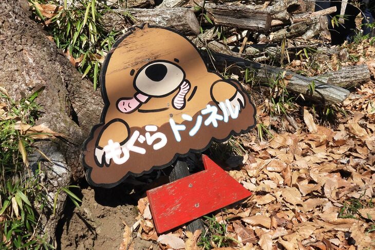 「もぐらトンネル」の看板。かじられているミミズの表情が、哀愁を誘う。