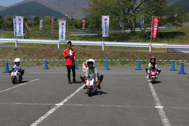チビッコ向けのバイク乗車体験「親子バイク祭り」。レーサーとモトクロスのポケバイが用意され、4歳～12歳の自転車に乗れる子供たちが対象だった。グローブやヘルメットも用意され、気軽に参加可能。どの子供たちもバイクをうまく乗りこなしていてビックリである。