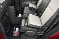 収納スペースは、2列目シート足元のフロア（写真）や助手席のシートクッション下、荷室のフロアなど至るところに用意される。また、写真のチャイルドブースターシート（オプション）は子供が正常位置でシートベルトを装着できるように座面の高さを調整できるもの。