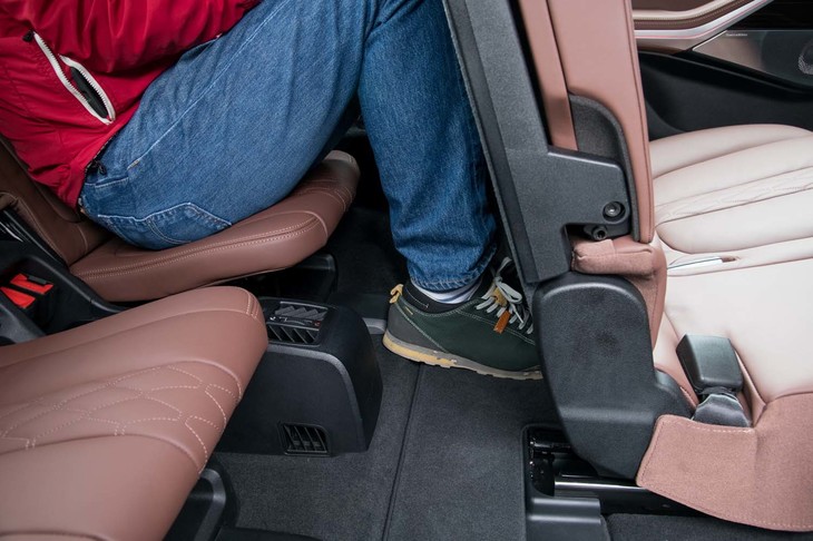 3列目に身長178cmの男性が乗り込んだところ。足元空間は狭いが、2列目シートの下が広く開いており、つま先が入るようになっている。